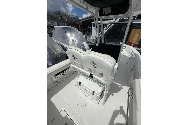 Slide: The Image of 2022 Edgewater 230CC boat interior with white seating and console. - 13