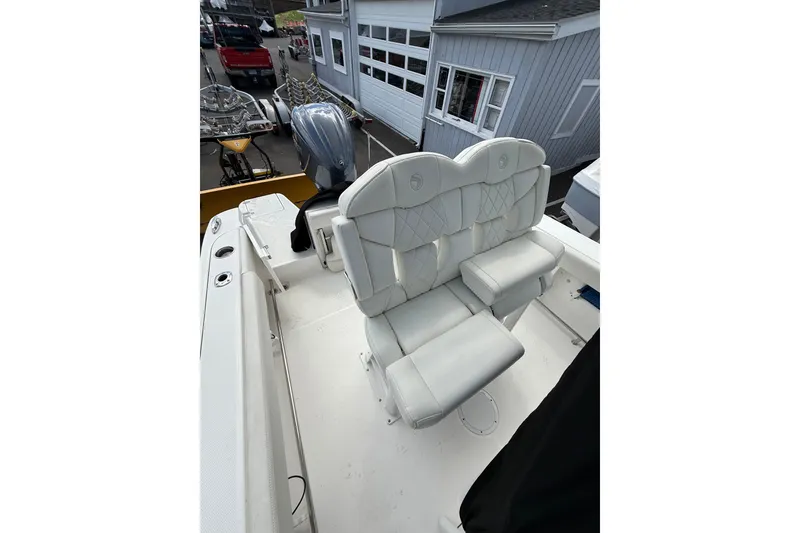 Slide: The Image of 2022 Edgewater 230CC boat with dual white cushioned seats and outboard motor. - 18