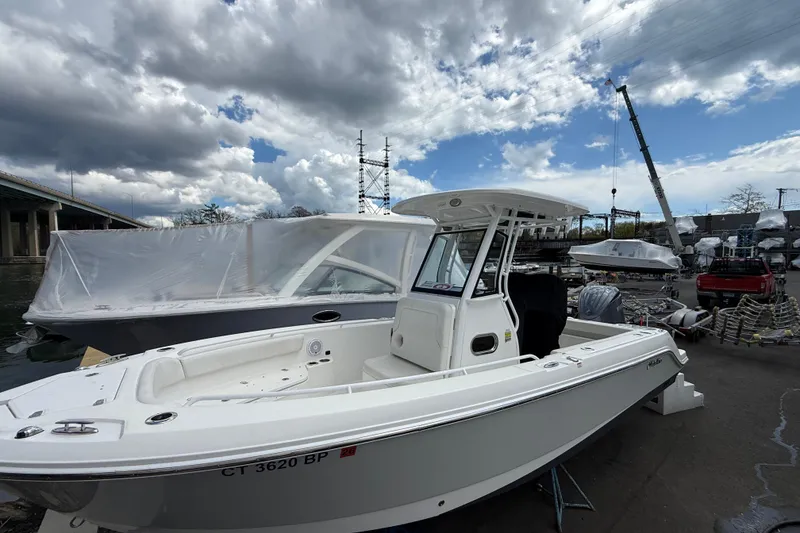 Slide: The Image of 2022 Edgewater 230CC boat docked under cloudy sky, showcasing sleek design and modern features. - 6
