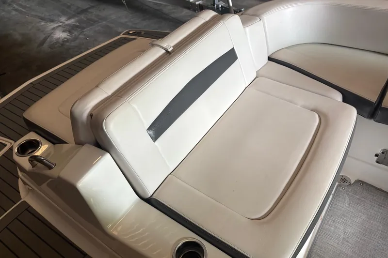 Slide: The Image of 2016 Chaparral 244 Sunesta boat interior with white cushioned seating and cup holders. - 10