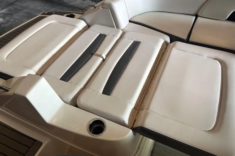 Slide: The Image of 2016 Chaparral 244 Sunesta boat interior seating, featuring white and gray upholstery. - 11