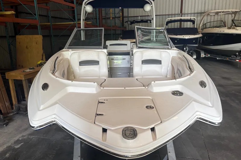 Slide: The Image of 2016 Chaparral 244 Sunesta boat in storage, showcasing sleek design and spacious seating. - 14