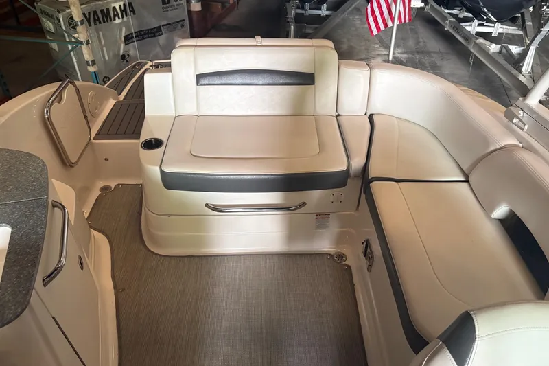 Slide: The Image of Interior of a 2016 Chaparral 244 Sunesta boat with beige seating and American flag. - 4