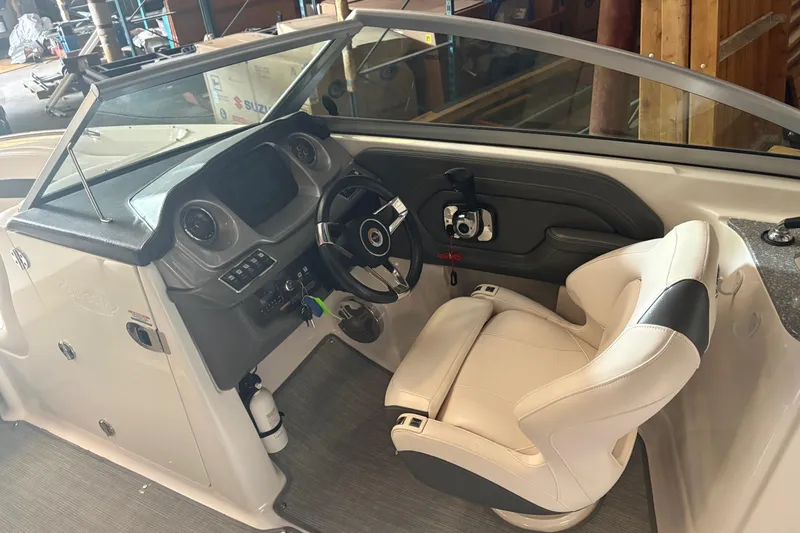 Slide: The Image of 2016 Chaparral 244 Sunesta boat cockpit with steering wheel and white captain's chair. - 5