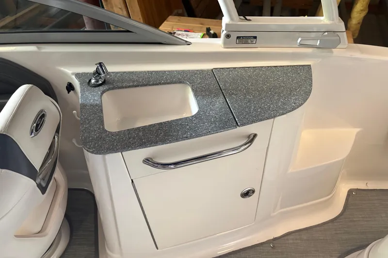Slide: The Image of Interior of 2016 Chaparral 244 Sunesta boat featuring a compact sink and storage area. - 7