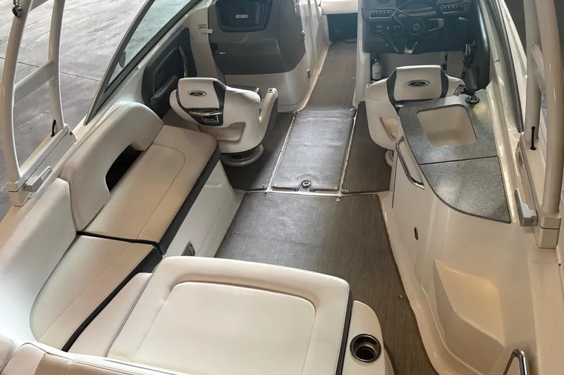 Slide: The Image of 2016 Chaparral 244 Sunesta boat interior with seating, steering, and sink area. - 9