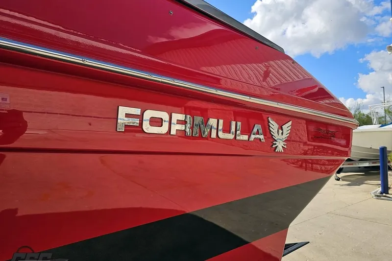 Slide: The Image of Red 1997 Formula 382 FASTech boat with logo, under a partly cloudy sky. - 21