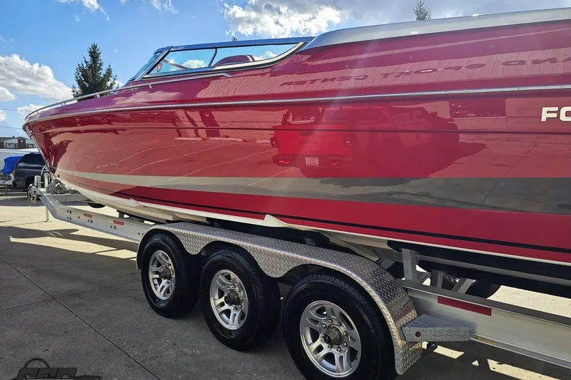 Slide: The Image of Red 1997 Formula 382 FASTech boat on a trailer under a clear blue sky. - 23