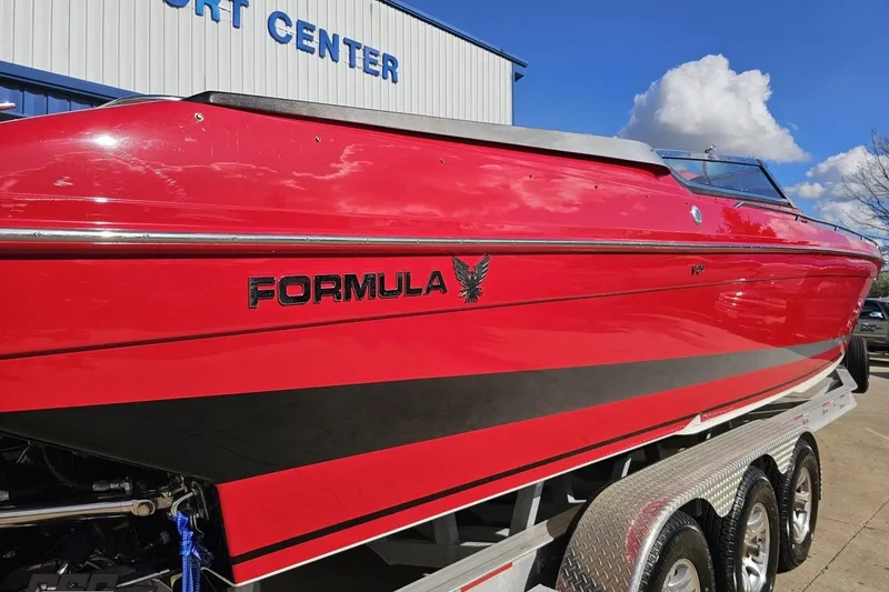 Slide: The Image of Red 1997 Formula 382 FASTech boat on trailer, parked outside a building under a blue sky. - 30