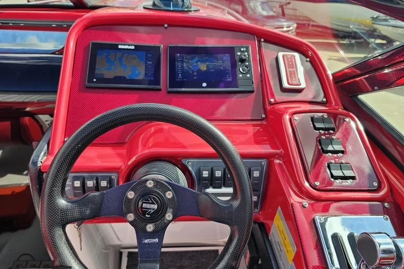 Slide: The Image of Red dashboard of a 1997 Formula 382 FASTech boat with steering wheel and navigation screens. - 64