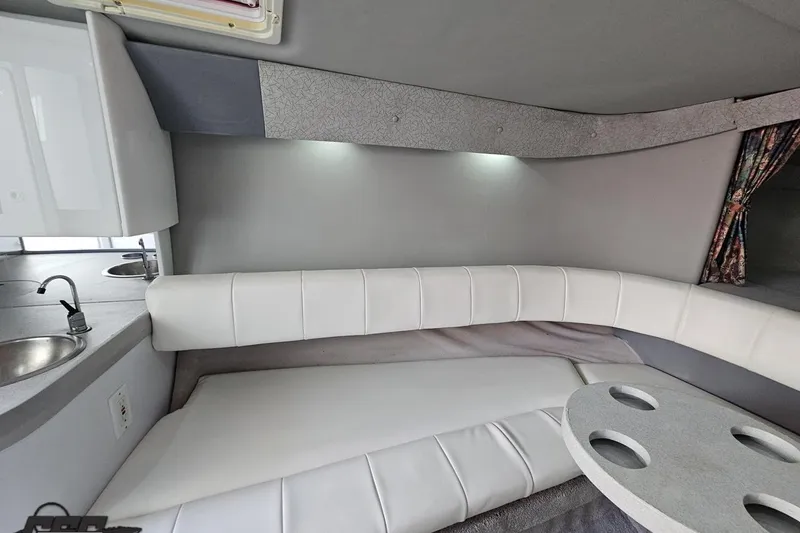 Slide: The Image of Interior of a 1997 Formula 382 FASTech boat with white seating and compact kitchenette. - 79