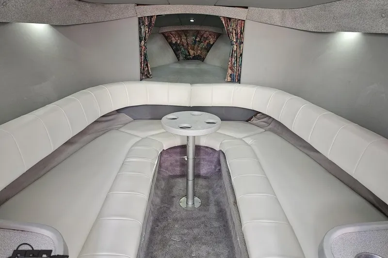 Slide: The Image of Interior of a 1997 Formula 382 FASTech boat with white seating and a central table. - 82