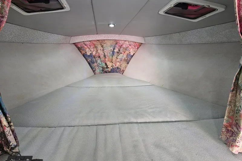 Slide: The Image of Interior cabin of a 1997 Formula 382 FASTech boat, featuring colorful curtains and a spacious layout. - 83