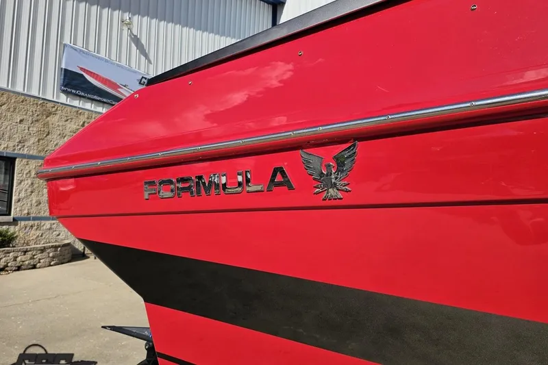 Slide: The Image of Red 1997 Formula 382 FASTech boat with logo, parked outside a building. - 9