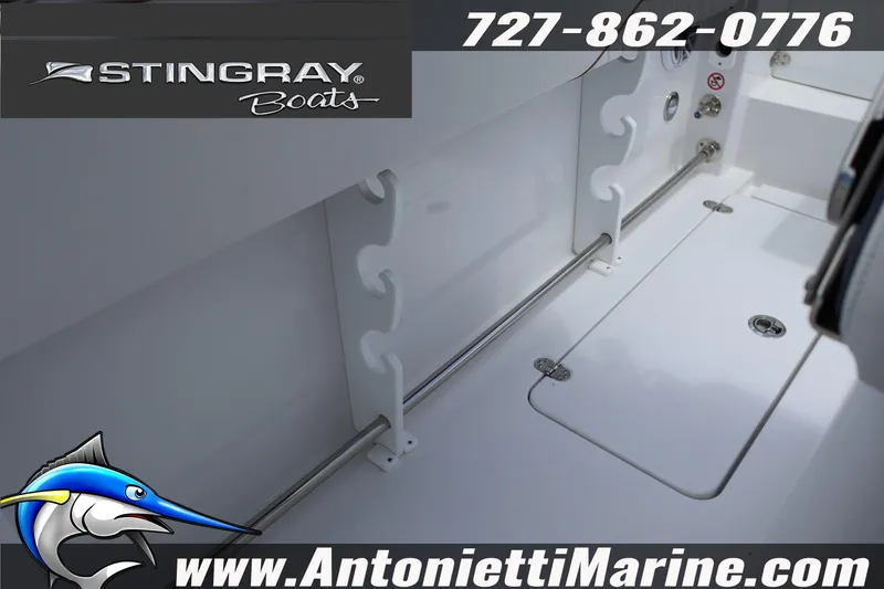 Slide: The Image of 2026 Stingray 253 CC boat interior with rod holders and storage compartment. - 17