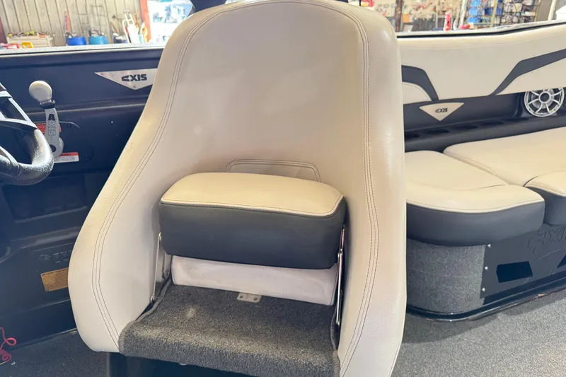 Slide: The Image of 2015 Axis T23 boat interior with beige seating and steering wheel. - 13