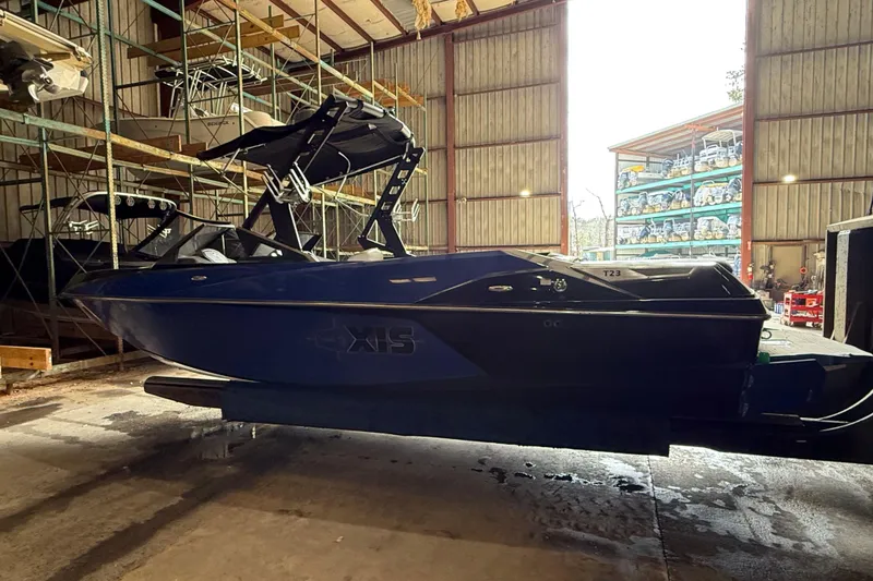 Slide: The Image of 2015 Axis T23 boat in storage facility, side view with racks and open doors. - 3