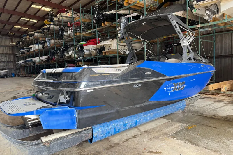 Slide: The Image of 2015 Axis T23 boat in storage, blue and black design, indoor facility. - 4