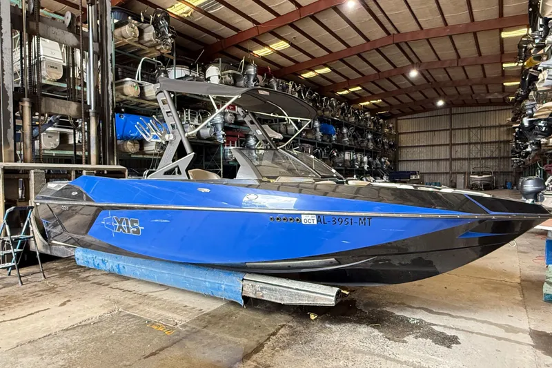 Slide: The Image of 2015 Axis T23 boat in storage facility, blue and black design. - 6