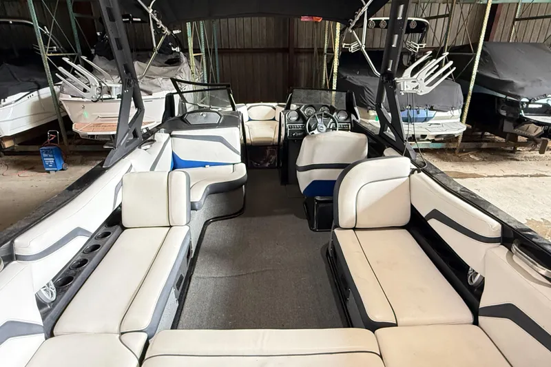 Slide: The Image of 2015 Axis T23 boat interior with spacious seating and modern dashboard in storage. - 9