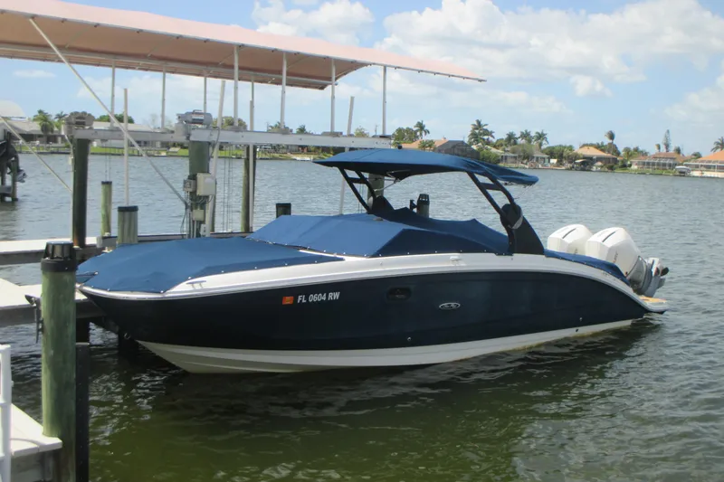 The Image of 2019 Sea Ray 290 SLX boat docked on a sunny day with blue cover. - 0