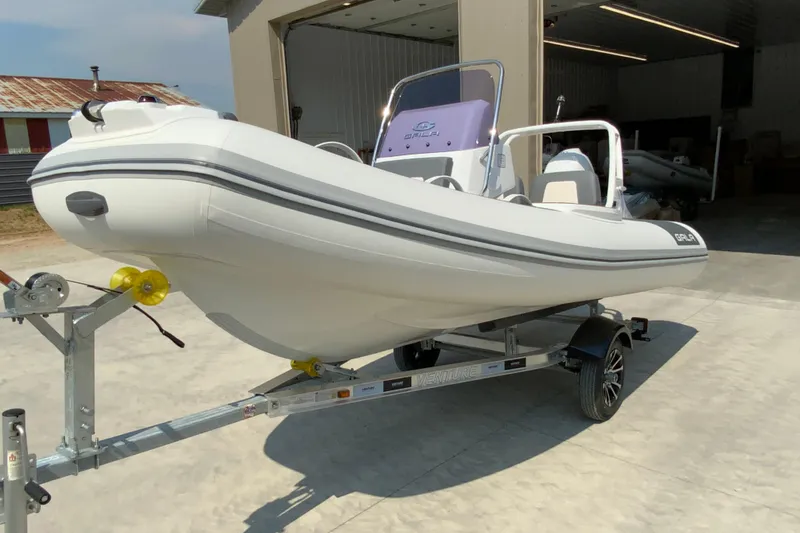 Slide: The Image of 2027 Gala V420 boat on trailer, parked outside a garage, ready for transport. - 3
