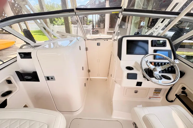 Slide: The Image of 2022 Grady-White Freedom 235 boat interior with steering wheel and control panel. - 11