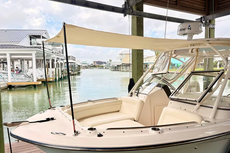 Slide: The Image of 2022 Grady-White Freedom 235 boat docked in a scenic waterfront setting. - 12