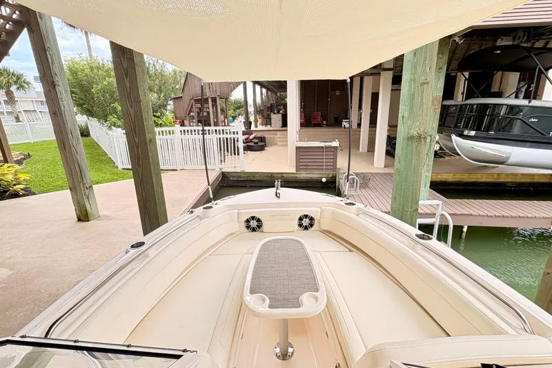 Slide: The Image of 2022 Grady-White Freedom 235 boat docked under a canopy in a marina setting. - 16