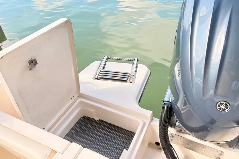 Slide: The Image of 2022 Grady-White Freedom 235 boat with open storage compartment and ladder near water. - 4