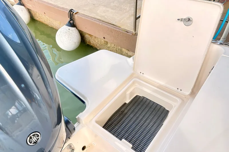 Slide: The Image of 2022 Grady-White Freedom 235 boat with open storage compartment near dock. - 5
