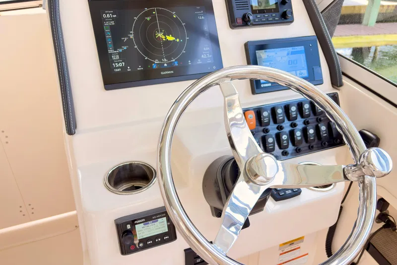 Slide: The Image of Control panel of 2022 Grady-White Freedom 235 boat with steering wheel and navigation displays. - 9