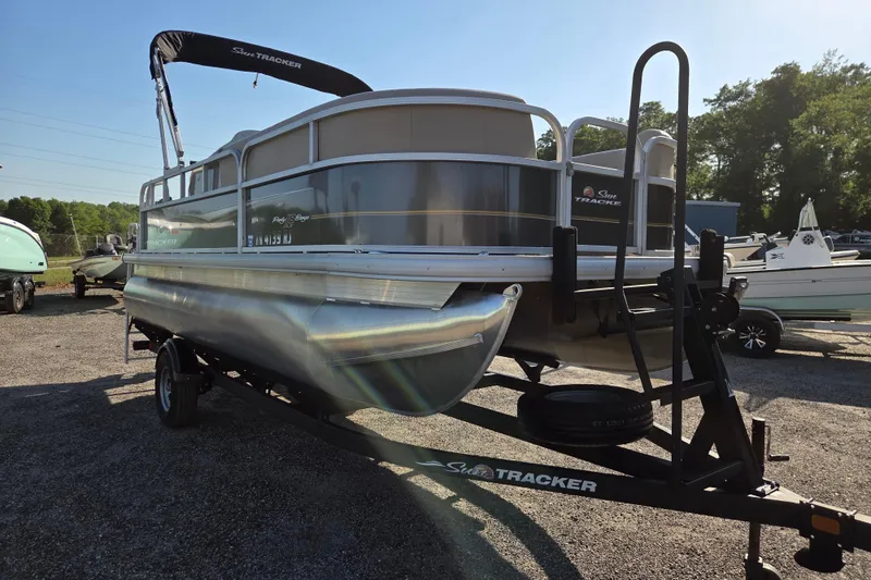 Slide: The Image of 2022 Sun Tracker Party Barge 18 DLX pontoon boat on trailer in outdoor setting. - 2