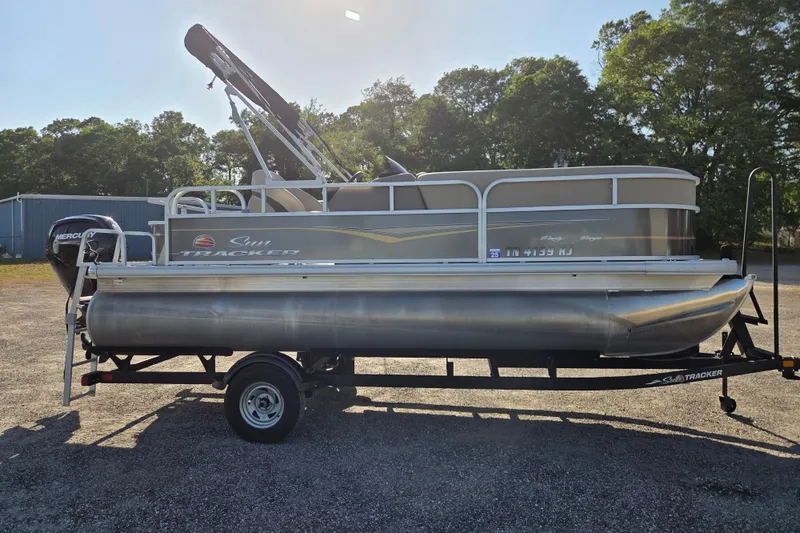 Slide: The Image of 2022 Sun Tracker Party Barge 18 DLX pontoon boat on trailer, parked outdoors. - 3