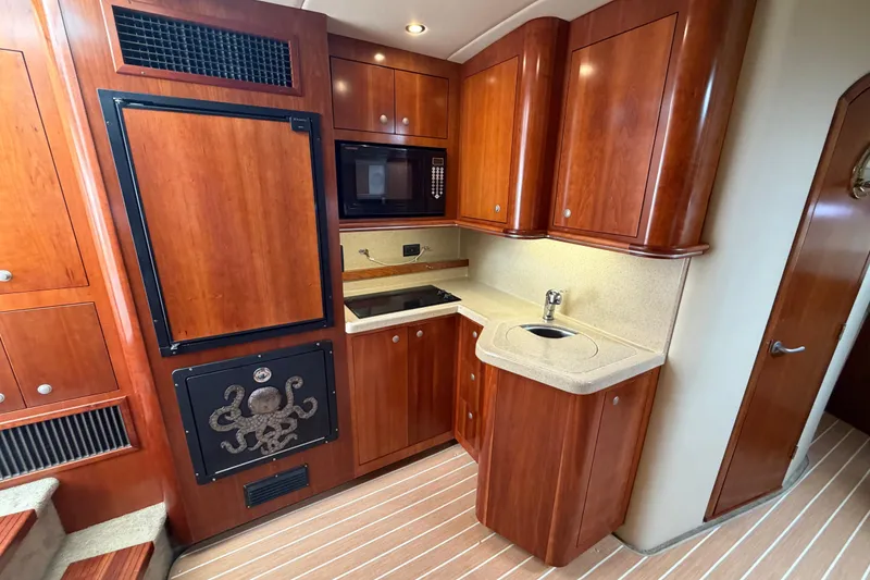 Slide: The Image of Luxurious 2007 Cruisers Yachts 370 Express kitchen with wood cabinetry and modern appliances. - 16