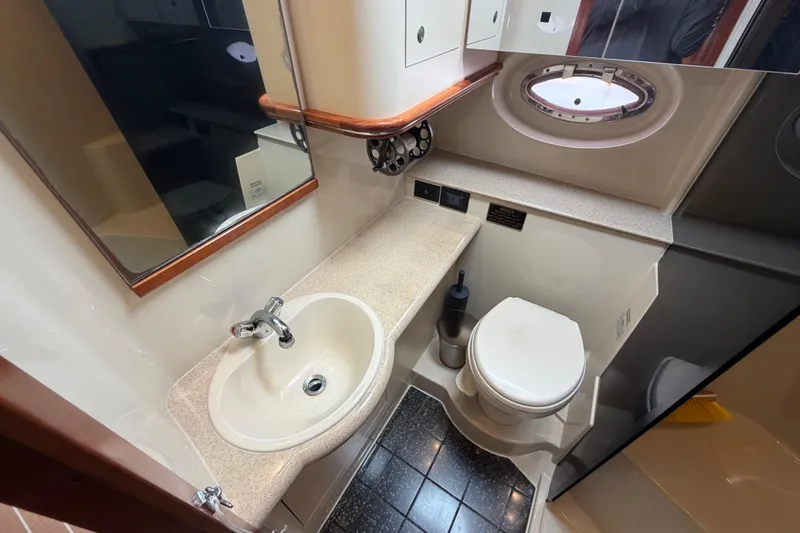 Slide: The Image of Bathroom interior of 2007 Cruisers Yachts 370 Express with sink, toilet, and porthole window. - 22