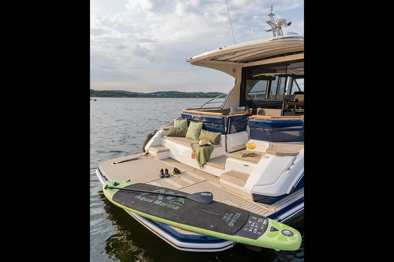 Slide: The Image of Manufacturer Provided Image: 2025 Marex 440 Scandinavia yacht with paddleboard on serene water. - 6