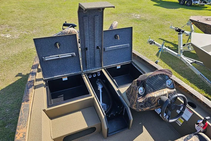 Slide: The Image of 2026 G3 Sportsman 1810 boat interior with open storage compartments and steering console. - 15