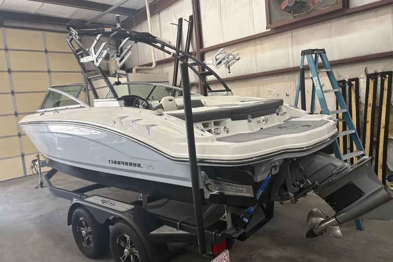Slide: The Image of 2022 Chaparral 21 Surf boat in a garage, showcasing sleek design and modern features. - 2