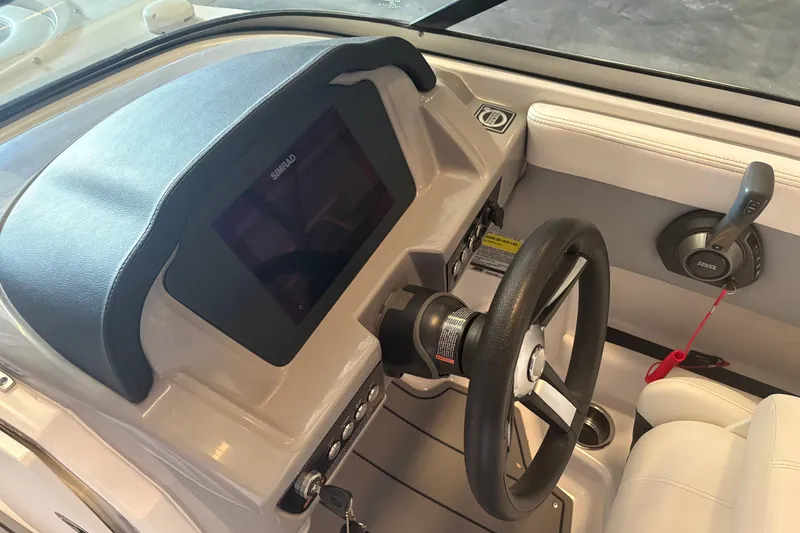 Slide: The Image of 2022 Chaparral 21 Surf boat dashboard with steering wheel and control panel. - 8