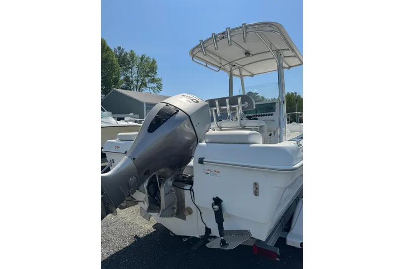 Slide: The Image of 2007 Triumph 215 TE boat with outboard motor and canopy, parked outdoors. - 2