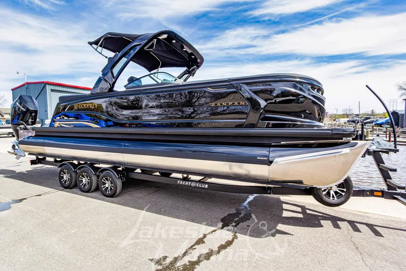 The Image of 2026 Godfrey Sanpan 2700 ULW Twin pontoon boat on trailer, dockside view. - 1