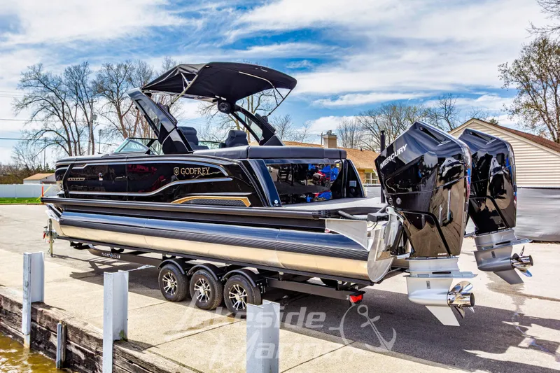 Slide: The Image of 2026 Godfrey Sanpan 2700 ULW Twin pontoon boat with dual Mercury engines on trailer. - 7