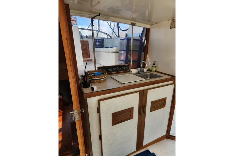 Slide: The Image of 1987 Jefferson 42 SE Sundeck Motor Yacht interior with kitchenette and sink area. - 14
