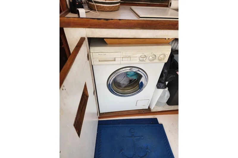 Slide: The Image of Washing machine inside 1987 Jefferson 42 SE Sundeck Motor Yacht, with wooden cabinetry and nautical mat. - 15
