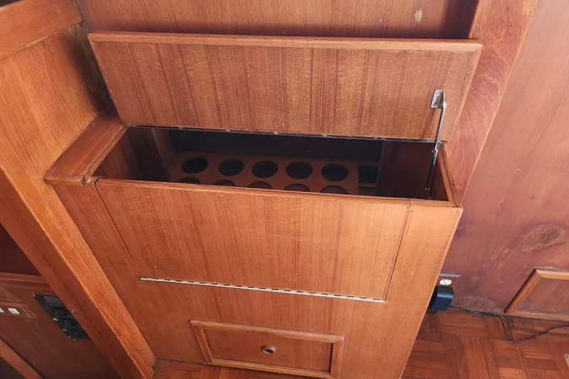 Slide: The Image of Wooden cabinet with open top, revealing storage space, inside a 1987 Jefferson 42 SE Sundeck Motor Yacht. - 18