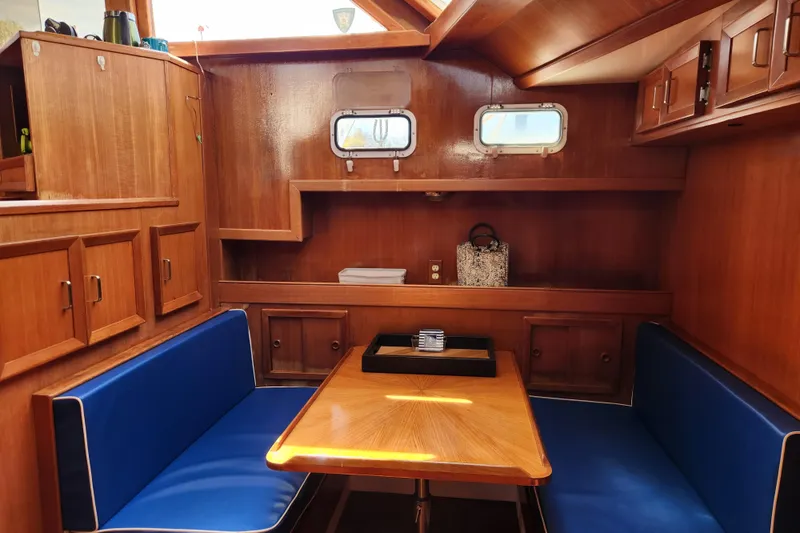 Slide: The Image of Interior of 1987 Jefferson 42 SE Sundeck Motor Yacht with wooden cabinetry and blue seating. - 23