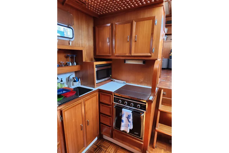 Slide: The Image of 1987 Jefferson 42 SE Sundeck Motor Yacht kitchen with wooden cabinets and modern appliances. - 25