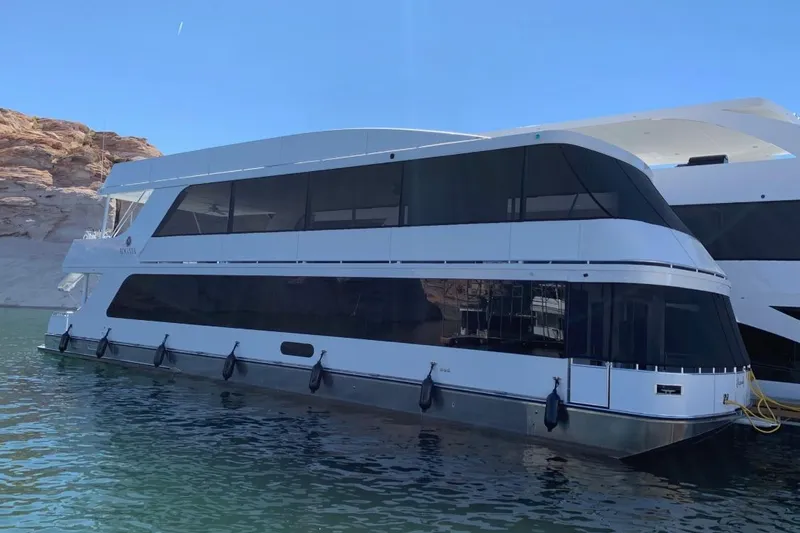 The Image of Modern Adonia houseboat on serene water, 2020 model, with scenic rocky backdrop. - 14
