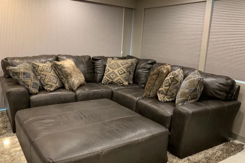 Slide: The Image of Luxurious brown leather sectional sofa with patterned cushions in a cozy living room setting. - 18